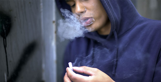 boy smoking nervously planning