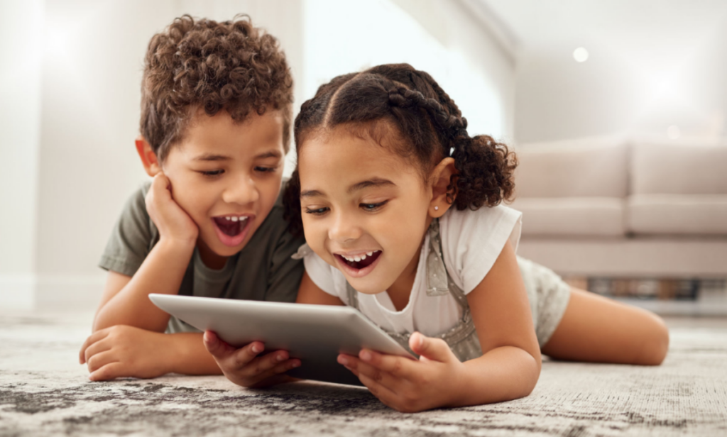 child looks happy while watching screens